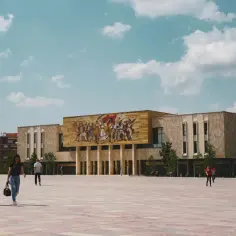 Plac Skanderbega w Tiranie, z monumentalnym budynkiem i mozaiką. Idealne miejsce, by zobaczyć w Tiranie, co oferuje stolica Albanii.