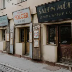 Kazimierz Kraków atrakcje: zabytkowe szyldy sklepów i salonu mody tworzą niepowtarzalny klimat ulicy.