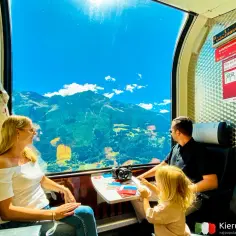 Rodzina podziwia alpejskie widoki z okna pociągu Bernina Express, jadąc z Bergamo do Werony.