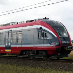 Nowoczesny pociąg ED74-001d PKP Intercity mija pole pszenicy w okolicach dworca PKP Brzeg.