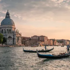 Wenecja w jeden dzień: gondole płynące po Canale Grande przy Bazylice Santa Maria della Salute w złotym świetle zachodzącego słońca.