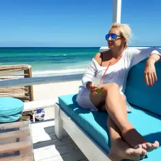 Kobieta z drinkiem na plaży w Tunezji. Czy jest bezpiecznie? Tak, relaks i słońce gwarantowane!