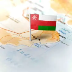 Flaga Omanu wbita w mapę, wskazująca gdzie leży Oman, nad Zatoką Omańską, blisko Maskatu i Oceanu Indyjskiego.
