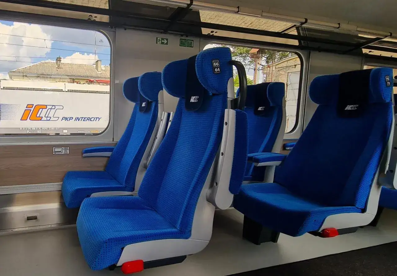 Wnętrze pociągu PKP Intercity z niebieskimi fotelami. Widać numerki 66 i 64 na zagłówku. Eic co to za pociąg?