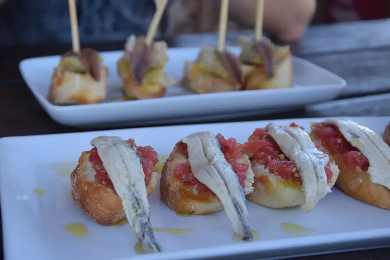 Tapas z sardelami i pomidorami na bagietce. Zastanawiasz się, ile kosztuje obiad w Barcelonie? Takie przekąski to świetny początek.