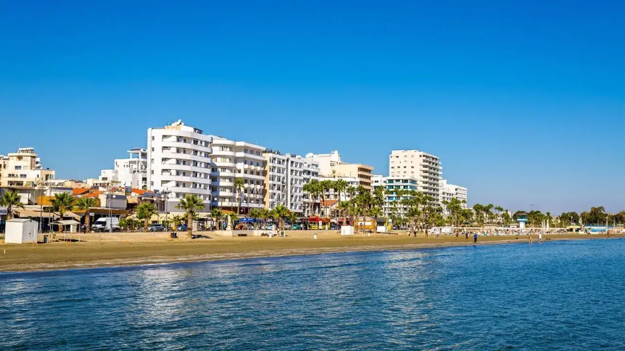 Larnaka: plaża Finikoudes z białymi budynkami i palmami, idealne miejsce, by zobaczyć urok miasta.
