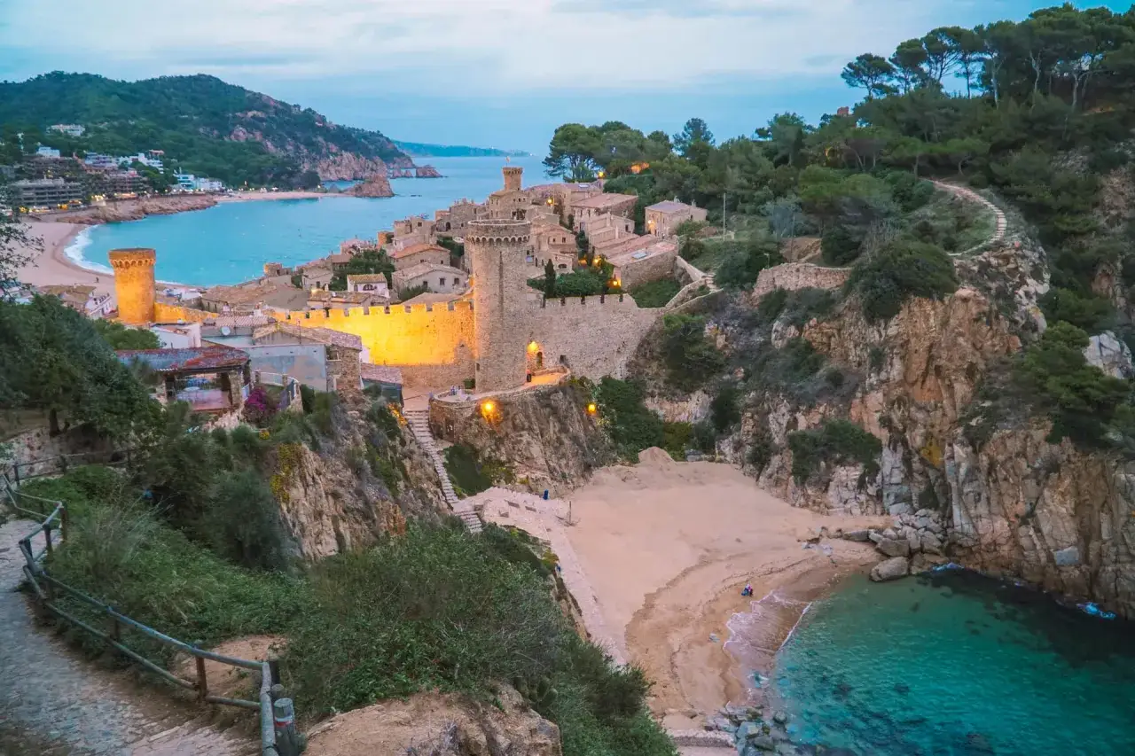 Malowniczy widok na średniowieczną wioskę z zamkiem i plażą, idealne miejsce na odkrywanie lloret de mar atrakcje.